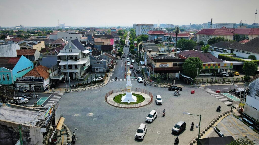 Aerial view of the Tugu Yogyakarta roundabout with bustling urban traffic.