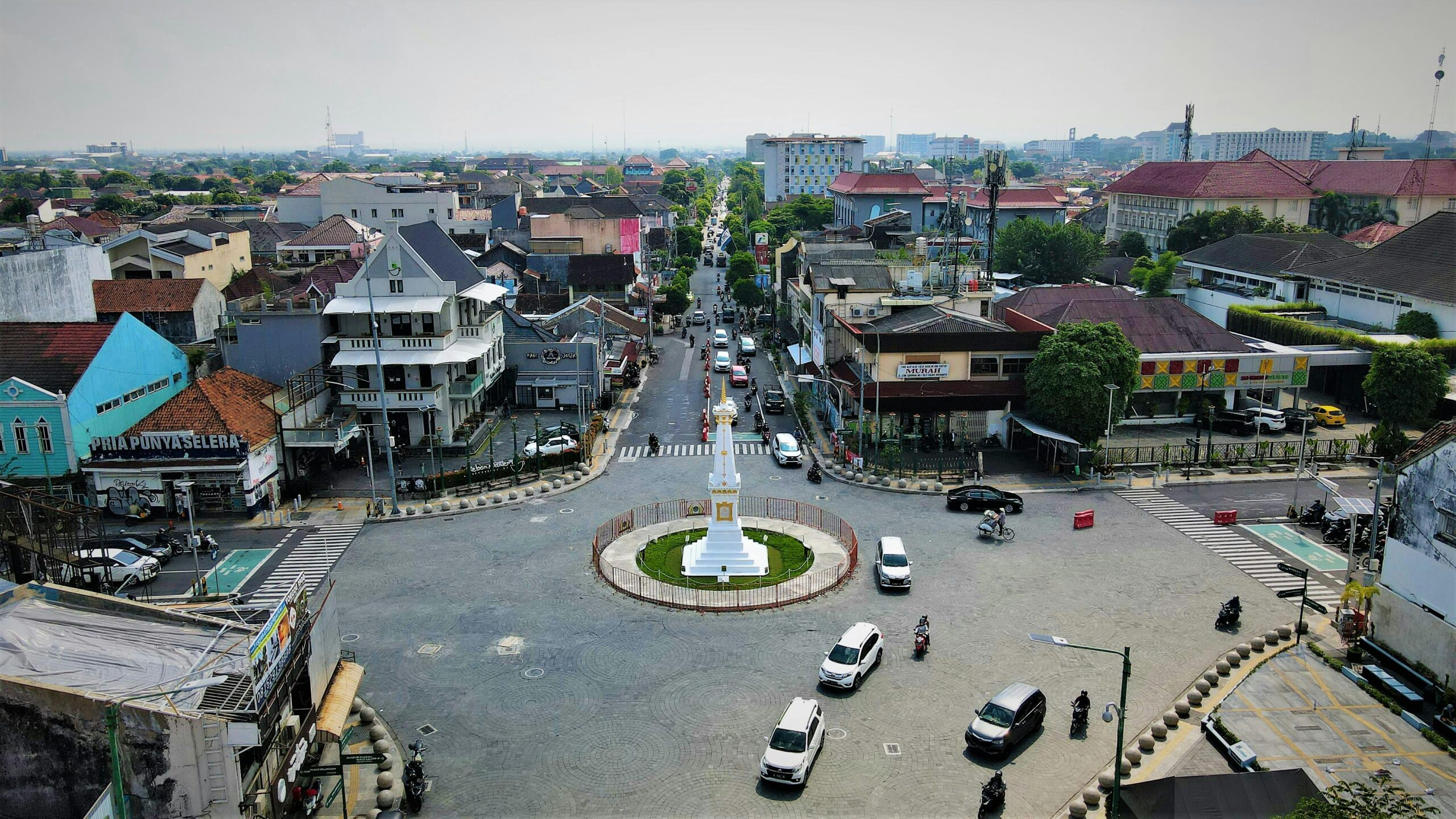 Aerial view of the Tugu Yogyakarta roundabout with bustling urban traffic.